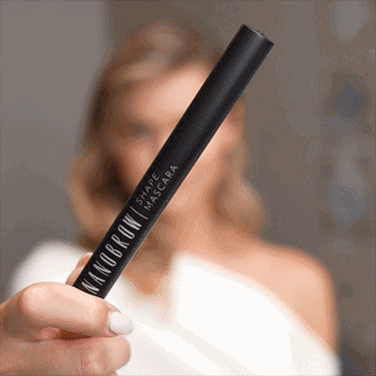 一位身穿白色连衣裙、正在涂抹形状睫毛膏的蓝眼睛女士