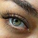 Close-up of a woman's eye with long, elegant eyelashes, showcasing DIY eyelash extensions for a classy look.